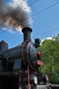 Steam locomotive, front of locomotive. Dense smoke rises from the chimney