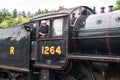 Steam locomotive train driver looking out of the cab of a heritage steam train