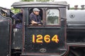 Steam locomotive train driver looking out of the cab of a heritage steam train