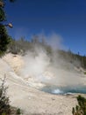 Steam rising from blue hot spring at Yellowstone National Park Royalty Free Stock Photo