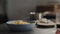 steam rising from boiled fusilli in blue bowl on concrete countertop