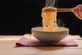 Instant noodles in bowl on wooden table and nature light and black background