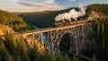 Steam train crossing scenic forested canyon bridge at sunset Royalty Free Stock Photo
