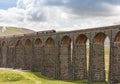 Steam train half way across Ribble Head viaduct in north Yorkshire in summer