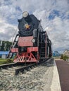 Steam train on a pedestal- monument L-0154 is installed near the railway station in Kamen-na-Obi, Altai, Russia. Vertical
