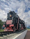 Steam train on a pedestal- monument L-0154 is installed near the railway station in Kamen-na-Obi, Altai, Russia. Vertical