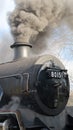 Steam train with smoke billowing from its stack. Royalty Free Stock Photo