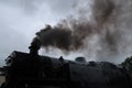 Steam train with smoke exiting its chimney.