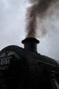 Steam train with smoke exiting its chimney.