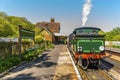 A steam train waiting at a station on a railway line in Sussex, UK Royalty Free Stock Photo