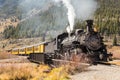 Steam train with yellow wagons going uphill Royalty Free Stock Photo