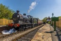 Steam trains passing at a station on a railway line in Sussex, UK