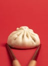 Bao dumpling close-up and chopsticks isolated on a red background Royalty Free Stock Photo