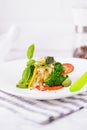 Steamed cod fish fillet with broccoli, tomato, lemon, avocado, basil sauce and pine nuts on a white background. Copy space Royalty Free Stock Photo