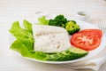 Steamed cod fish. Paleo, keto, fodmap healthy diet with vegetables on white plate on white table, side view.