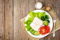 Steamed cod fish. Paleo, keto, fodmap healthy diet with vegetables on white plate on white table, side view. Royalty Free Stock Photo