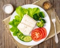 Steamed cod fish. Paleo, keto, fodmap healthy diet with vegetables on white plate on white table, side view. Royalty Free Stock Photo