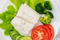 Steamed cod fish. Paleo, keto, fodmap healthy diet with vegetables on white plate on white table, top view.