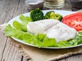 Steamed cod fish. Paleo, keto, fodmap healthy diet with vegetables on white plate on wooden table, side view Royalty Free Stock Photo