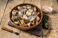 Steamed cooked shells Clams vongole in a wooden plate. wooden background. Top view