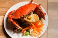 Steamed crab or Boiled crab fresh with crab`s spawn in white dish showing the delicious crab`s eggs inside its shell on wood table Royalty Free Stock Photo