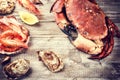 Steamed crab, shrimps and fresh oysters on wooden background