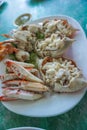 A pile of fresh meaty steam crabs served on a white plate at a seafood restaurant in Thailand