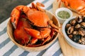 Steamed Giant Mud Crabs in wooden bowl served with Thai spicy seafood sauce and Grilled Laevistrombus Canarium in shell