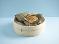 Steamed Glutinous Rice with Chicken Wrapped in Lotus Leaf served in a wooden bowl with chopsticks isolated on mat side view on Royalty Free Stock Photo