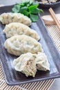 Steamed Korean dumplings Mandu with chicken meat and vegetables on black plate, vertical Royalty Free Stock Photo