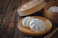 Steamed pork buns on wooden plate, Chinese dim sum