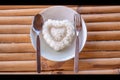 Steamed rice in the plate. Over wooden background.Cooked Rice On Plate. Heart shaped rice on a white plate. a bowl of rice on a Royalty Free Stock Photo