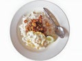 Steamed rice topped with fried chicken with garlic and pepper and fried egg. Arranged on a white plate and spoon. isolated white