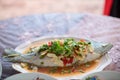 Steamed sea bass fish with lemon, Thai famous local food served on fish shape plate. Thai recommend menu for tourist.