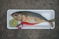 Steamed short mackerel served with red onion, lemon and red chili in foam tray