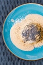 Steamed sweet dumpling bun topped with poppy seeds and vanilla sauce.