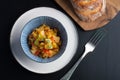 Steamed veggies in white cup with blue pattrn on the black table.flat lay