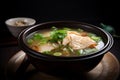 A steaming bowl of fragrant fish soup, garnished with a few slices of fresh ginger