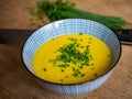 Steaming bowl of hearty soup garnished with fresh green chives, ready for consumption