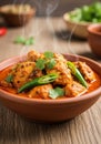 A steaming bowl of Indian curry features chunks of marinated chicken in a rich, Royalty Free Stock Photo