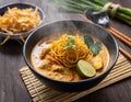 A steaming bowl of khao soi, a northern Thai curry noodle soup with tender chicken and crispy fried noodles on top