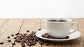 Steaming coffee cup, coffee beans, wooden table, isolated on white background Royalty Free Stock Photo