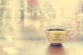 Steaming coffee cup with emotion message cup in coffee shop, front of mirror and raindrop window, Vintage color and soft concept