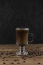 Steaming coffee over wooden surface and black background Royalty Free Stock Photo