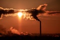 Steaming cooling towers and smoking industrial stacks against sunset gradient sky Royalty Free Stock Photo