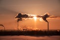 Steaming cooling towers and smoking industrial stacks against sunset gradient sky Royalty Free Stock Photo