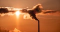 Steaming cooling towers and smoking industrial stacks against sunset gradient sky Royalty Free Stock Photo