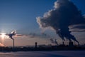 Steaming cooling towers and smoking industrial stacks against sunset gradient sky Royalty Free Stock Photo