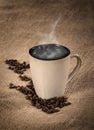 Steaming cup of coffee and coffee beans Royalty Free Stock Photo