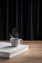 Steaming cup of tea or coffee on white book Royalty Free Stock Photo